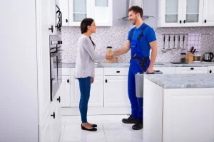 A plumber shaking hands with a homeowner, symbolizing trust and success achieved with business funding and a business line of credit from Forward Capital Solutions.