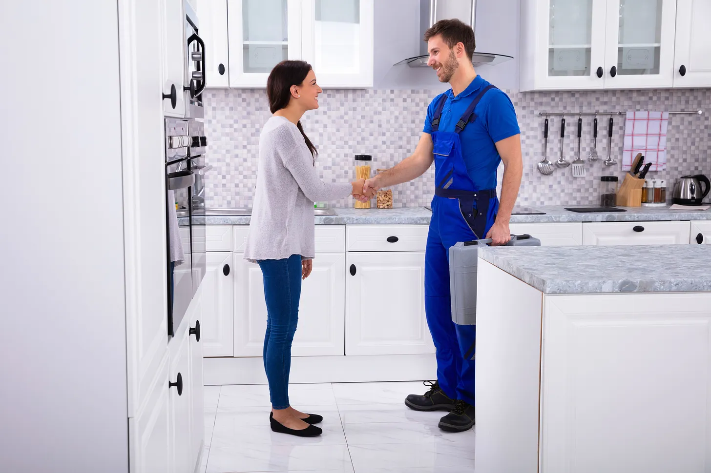 A plumber shaking hands with a homeowner, symbolizing trust and success achieved with business funding and a business line of credit from Forward Capital Solutions.